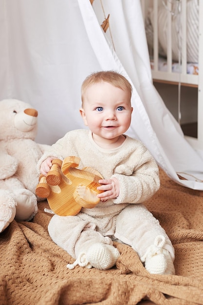 Neonato di 6 mesi che si siede e gioca con i giocattoli educativi. Buona maternità e paternità. Ospedale e clinica di maternità. Festa del papà e della mamma. Sviluppo della prima infanzia.