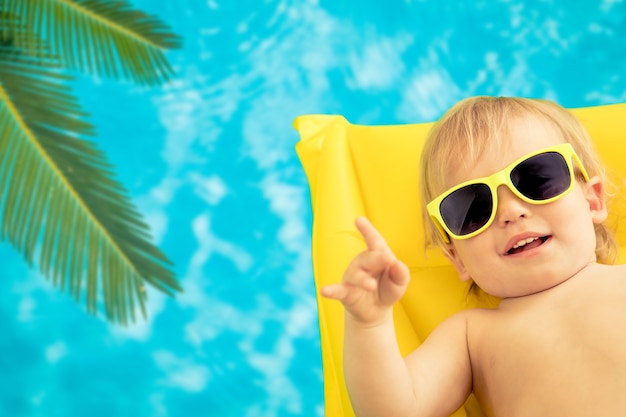 Neonato divertente in vacanza estiva. Bambino che si diverte in piscina