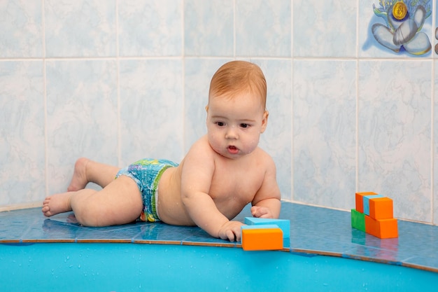 neonato in piscina che gioca con i giocattoli in cubi colorati