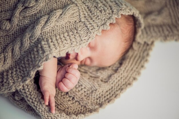 Neonato, lavorato a maglia Neonato avvolto in una coperta a maglia