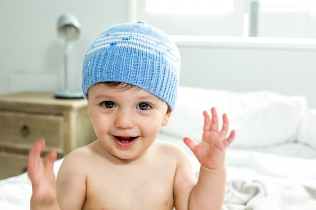 Neonato senza camicia che porta il cappello lavorato a maglia in camera da letto