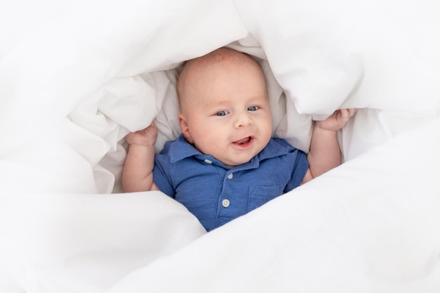 Neonato sorridente in una coperta in una culla il neonato felice si è svegliato la mattina o va a letto
