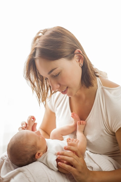 Neonato sveglio che dorme tra le braccia della madre. Maternità.