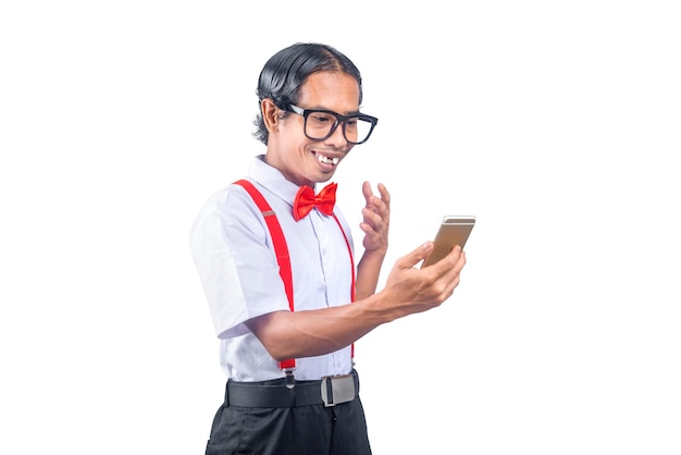 Nerd asiatico con una brutta faccia che tiene il telefono cellulare isolato su sfondo bianco