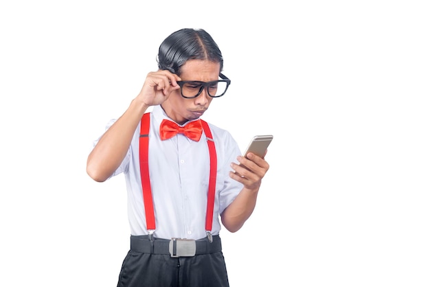 Nerd asiatico con una brutta faccia che tiene il telefono cellulare isolato su sfondo bianco