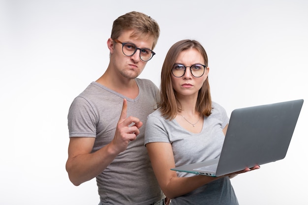 Nerd, studio, concetto di persone: un paio di studenti guardano con il laptop come se stessero pensando a qualcosa.