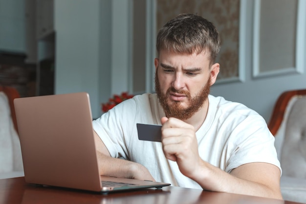 Nervoso triste sconvolto confuso giovane stressato ragazzo preoccupato che ha problemi con il pagamento dell'acquisto online