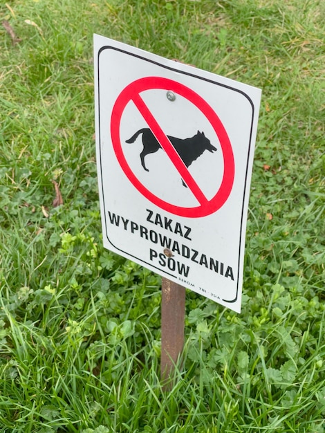 Nessun segno di cani Cartello bianco con iscrizione che vieta di camminare con il cane e divieto di defecazione nel parco