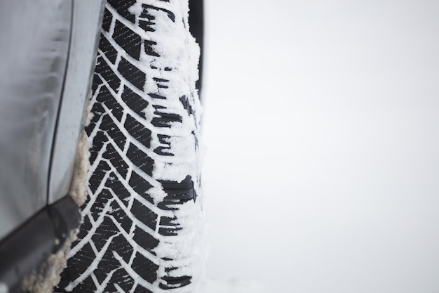 Neve bianca sullo spazio innevato della copia del fondo della gomma della ruota dell'automobile