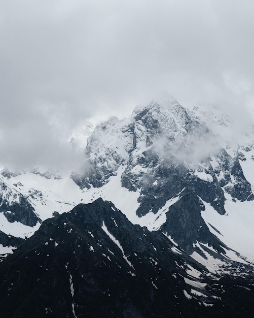 Neve in cima alle nuvole di montagna intorno