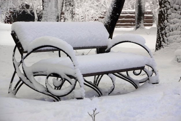 Neve sul banco nel parco del concetto di inverno