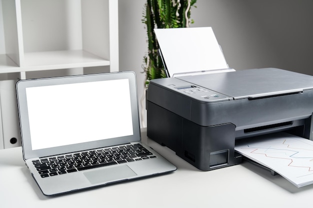 New modern printer and laptop in the office on table