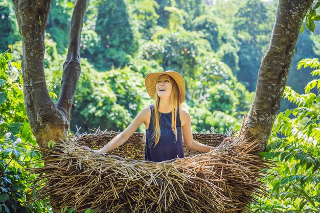 nidi di paglia alla moda di Bali ovunque Giovane turista che si gode il viaggio intorno all'isola di Bali Indonesia Fare una sosta su una bellissima collina Foto in un ambiente naturale di nido di paglia Stile di vita