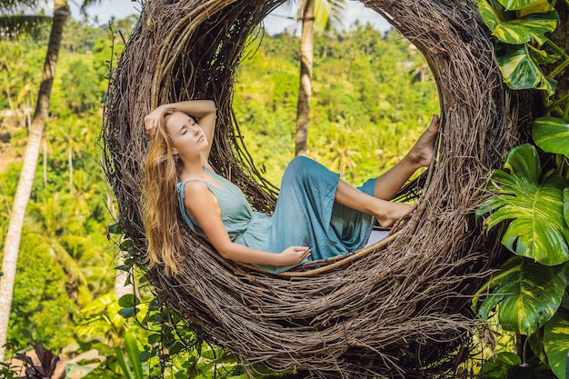 nidi di paglia alla moda di Bali ovunque Giovane turista che si gode il viaggio intorno all'isola di Bali Indonesia Fare una sosta su una bellissima collina Foto in un ambiente naturale di nido di paglia Stile di vita