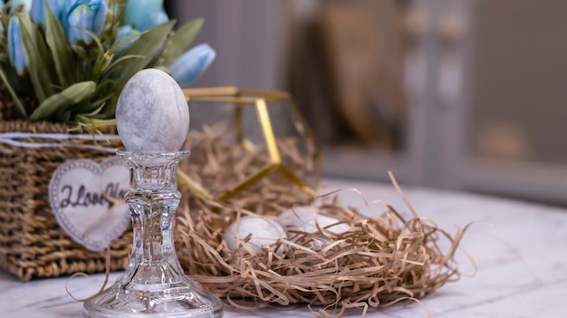 Nido decorativo con uova di Pasqua colorate in grigio