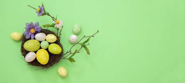 Nido di Pasqua Uovo di vernice color pastello e decorazione floreale su un tettuccio verde Vacanze di primavera