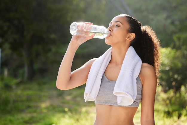 Niente di meglio dell'acqua. Inquadratura di una giovane donna che beve acqua durante un allenamento.