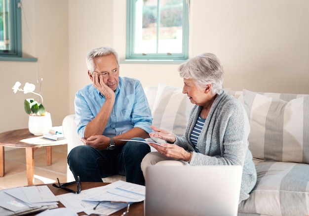 Niente mette a dura prova un matrimonio come lo stress finanziario Inquadratura di una coppia senior che ha un disaccordo mentre sta sbrigando le scartoffie a casa