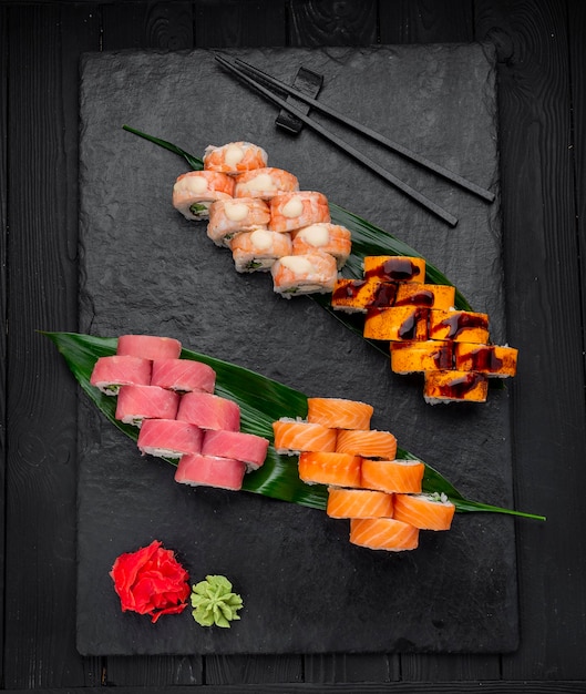 Nigiri di sushi assortiti e grande set di maki su ardesia Una varietà di sushi giapponese con anguilla di salmone granchio tonno e involtini
