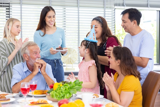 Nipote a sorpresa con torta al cioccolato per la festa di compleanno con la famiglia dopo cena a casa