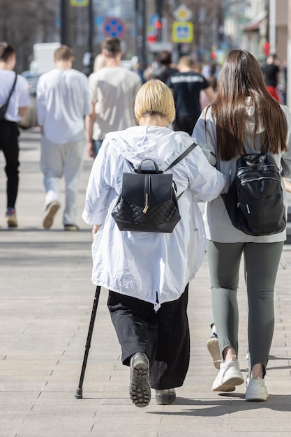 Nipote adolescente che aiuta la nonna a camminare