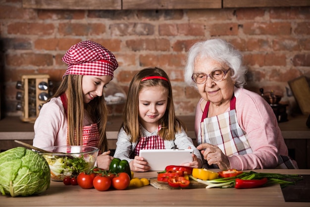 Nipote e nonna con tablet alla ricerca di ricette