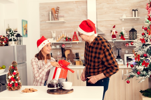 Nipote e nonno si sorridono a vicenda festeggiando il natale