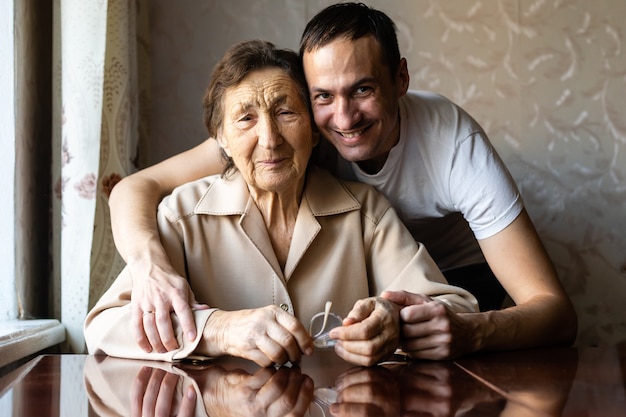 Nipote felice che abbraccia sua nonna a casa