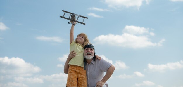 Nipote figlio e nonno con aereo giocattolo su sfondo blu cielo e nuvole due uomini generazione