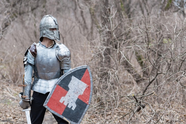 Nobile guerriero Ritratto di un guerriero medievale o cavaliere in armatura e casco con scudo e spada in posa