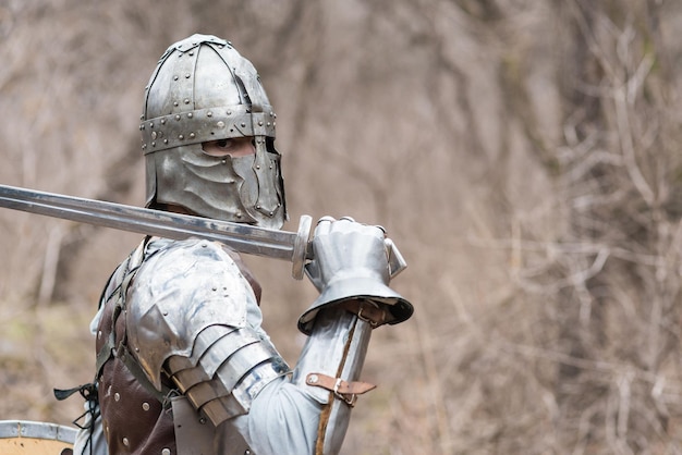 Nobile guerriero Ritratto di un guerriero medievale o cavaliere in armatura e casco con scudo e spada in posa