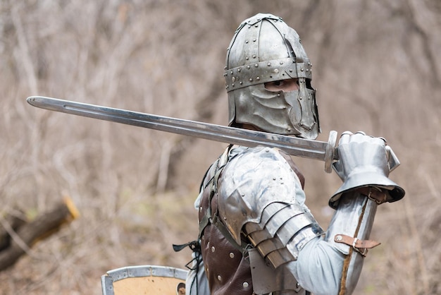 Nobile guerriero Ritratto di un guerriero medievale o cavaliere in armatura e casco con scudo e spada in posa