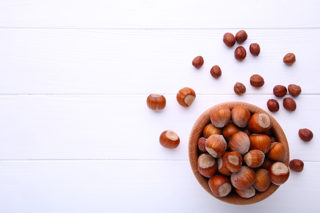 Nocciola deliziosa nella ciotola di legno su bianco