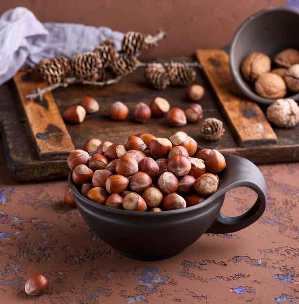 Nocciola in una conchiglia in una tazza di argilla marrone