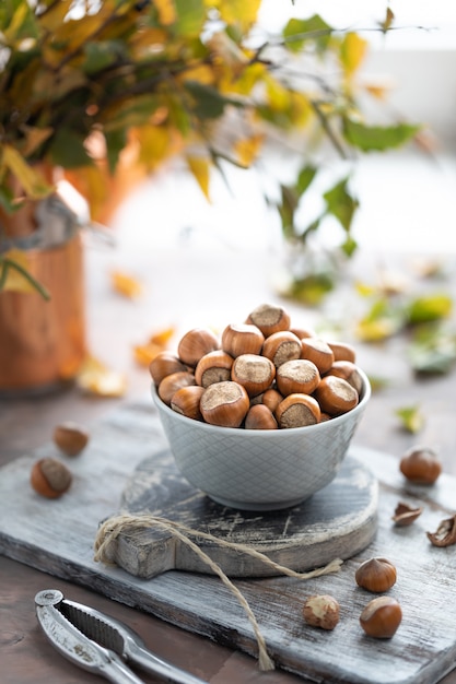 Nocciole in una tazza di ceramica sul tavolo. Natura morta autunnale