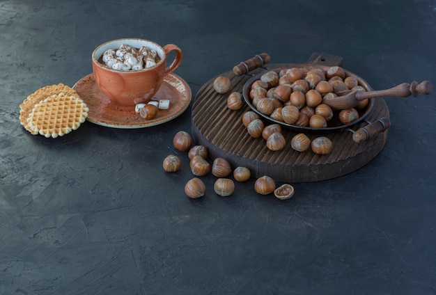 nocciole, waffle e una tazza di cioccolata calda con marshmallow