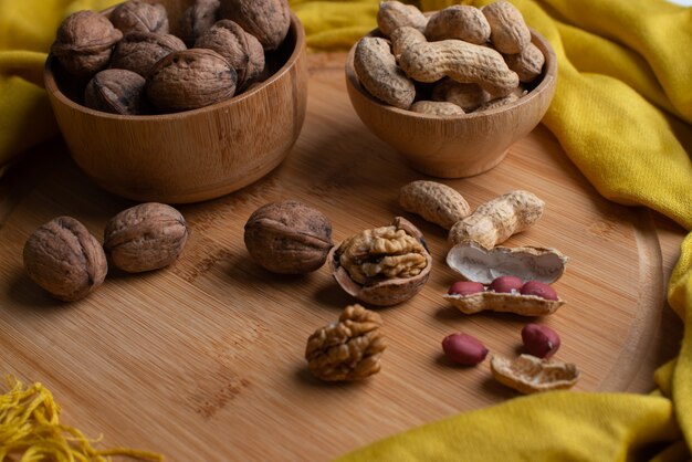 Noccioli delle noci su fondo di legno, noci in ciotola di legno di bambù