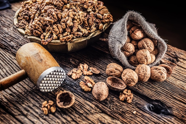 Noccioli di noce noci intere in sacco di tela e ciotola vintage.