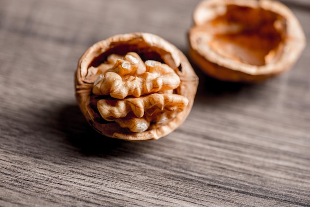 Noccioli di noci su scrivania in legno con fondo di dettaglio, noce su fondo cucina in legno.