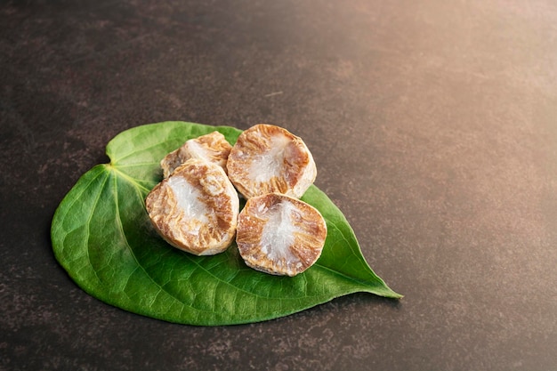 Noce di betel o di areca fresche con foglie di betel isolate su sfondo scuro