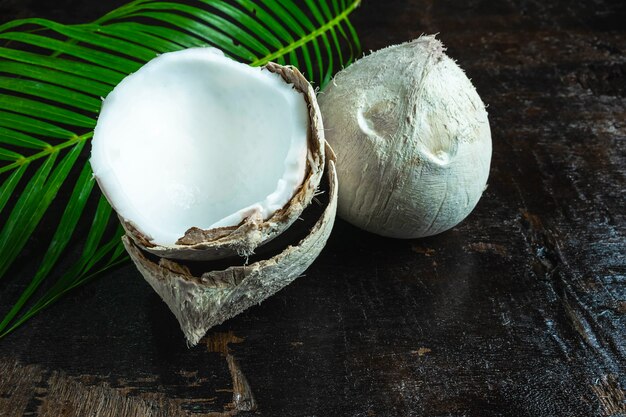 noce di cocco con foglie su fondo in legno