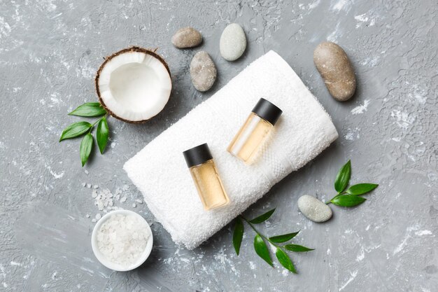 Noce di cocco con vasetti di olio di cocco e crema cosmetica su sfondo colorato Vista dall'alto Spazio libero per il testo Cosmetici spa naturali al cocco e concetto di trattamento biologico Composizione Spa al cocco