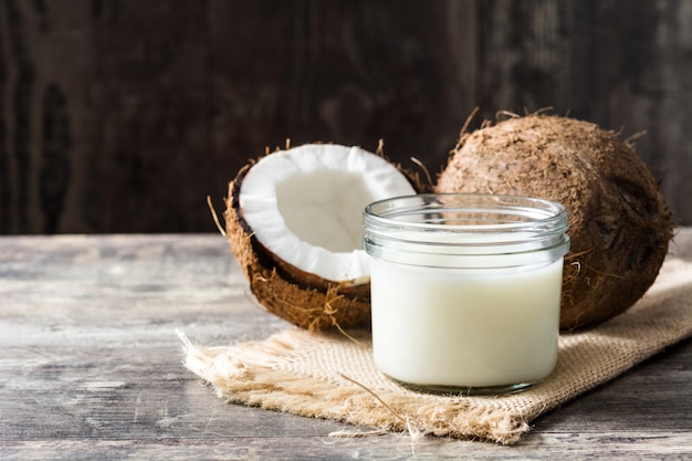 Noce di cocco e latte di cocco sulla tavola di legno