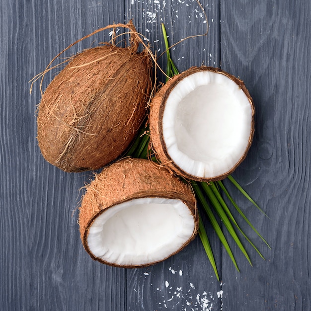 Noce di cocco marrone tre sul bordo di legno anziano