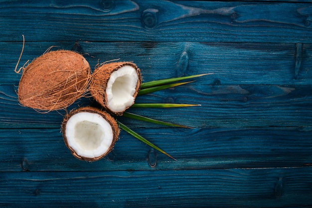 Noce di cocco su uno sfondo di legno Frutta e noci tropicali Vista dall'alto Spazio libero per il testo