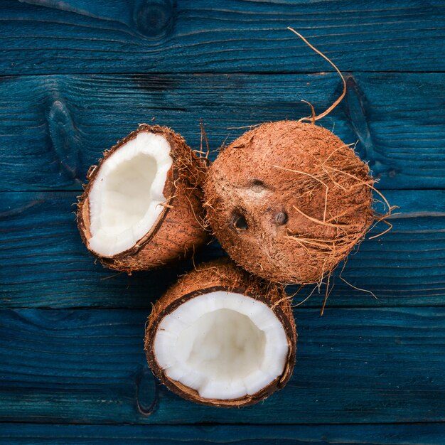 Noce di cocco su uno sfondo di legno Frutta e noci tropicali Vista dall'alto Spazio libero per il testo