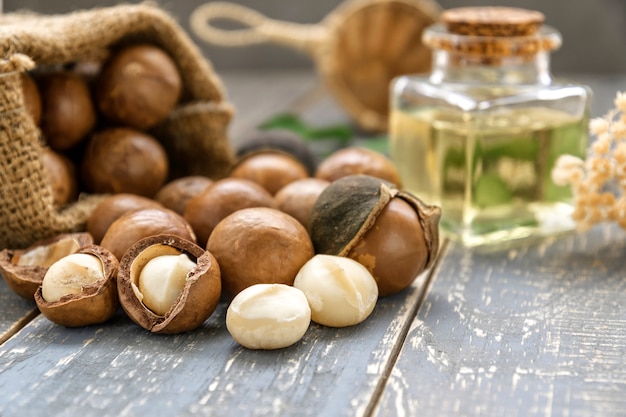 Noce di macadamia organica sulla tavola di legno - filtro d'annata.