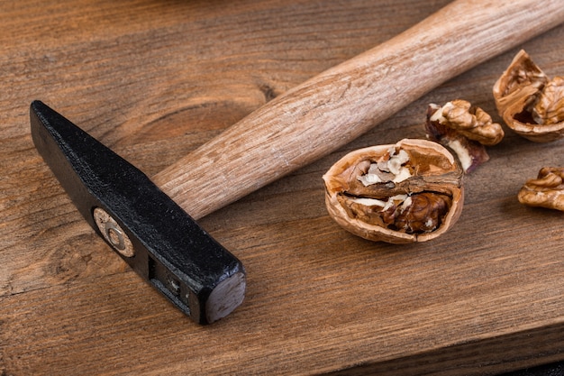 Noce e martello su una tavola di legno