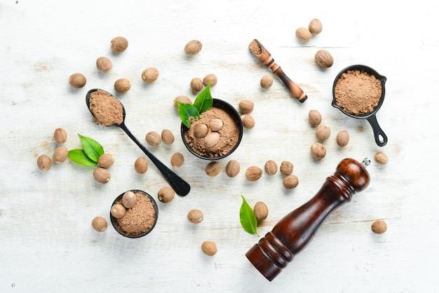 Noce moscata aromatica su un tavolo di legno bianco. Spezie indiane.