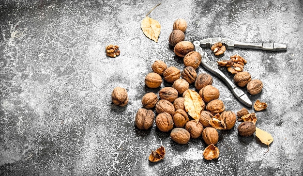 Noci con lo schiaccianoci sul tavolo rustico.